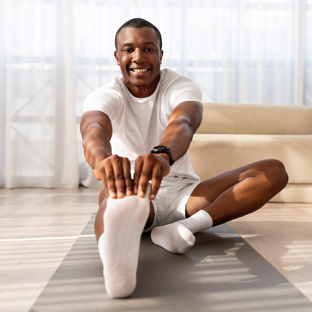 Young man stretching on a yoga mat